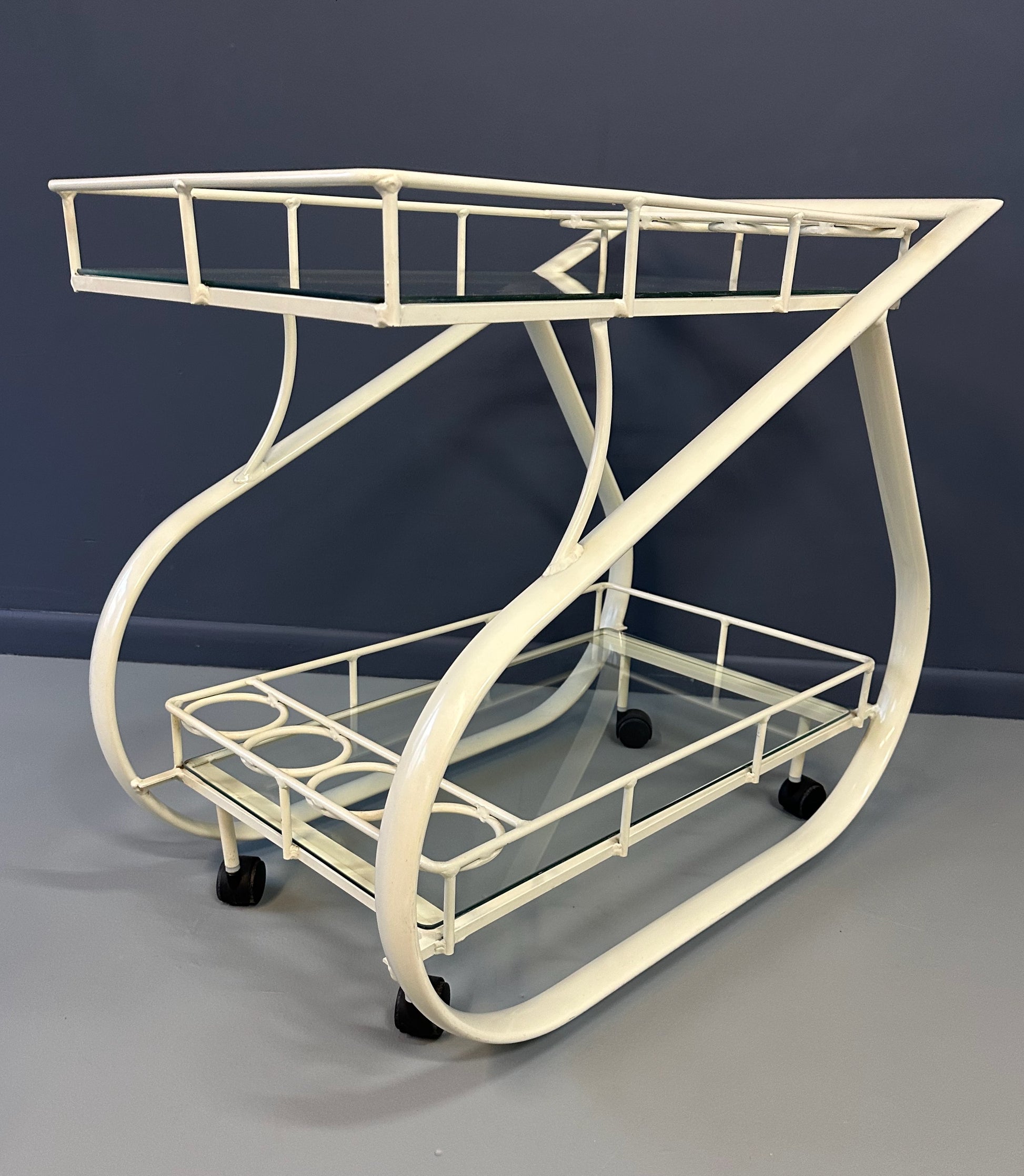 Vintage 1980s postmodern two-tier bar cart with curvy metal frame and glass shelves, attributed to Woodard