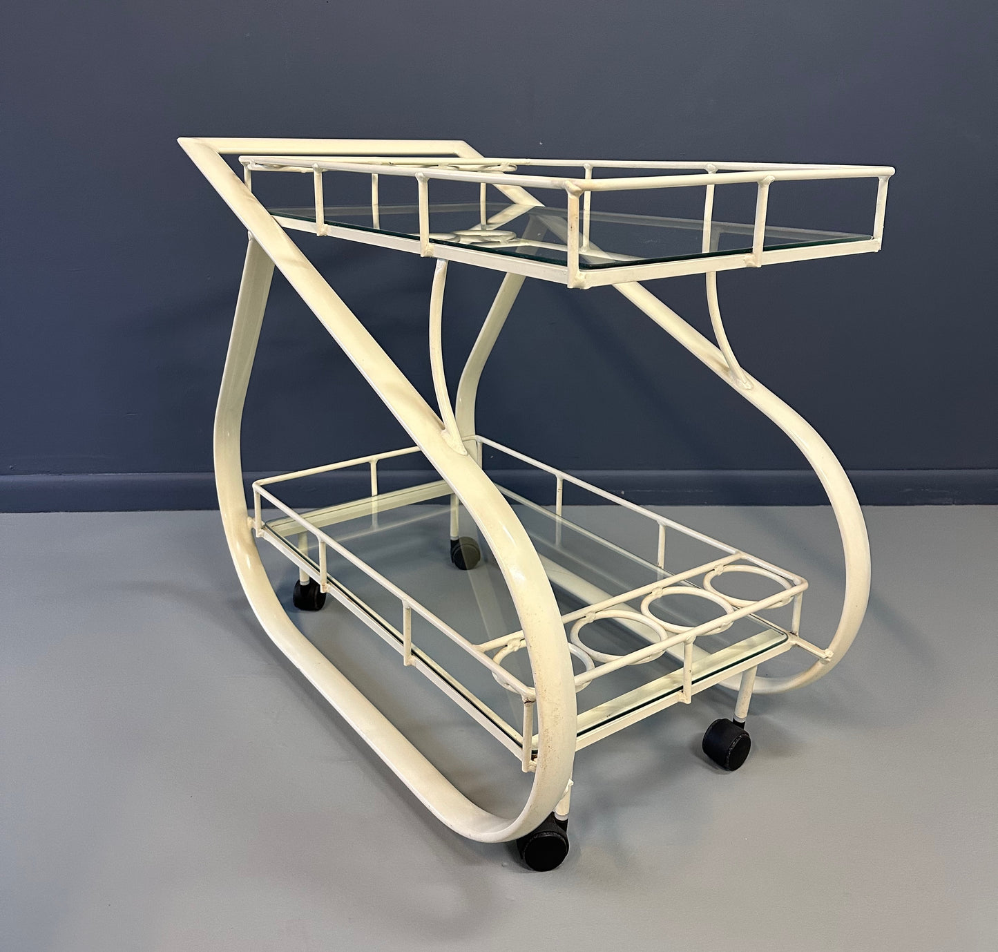 Vintage 1980s postmodern two-tier bar cart with curvy metal frame and glass shelves, attributed to Woodard