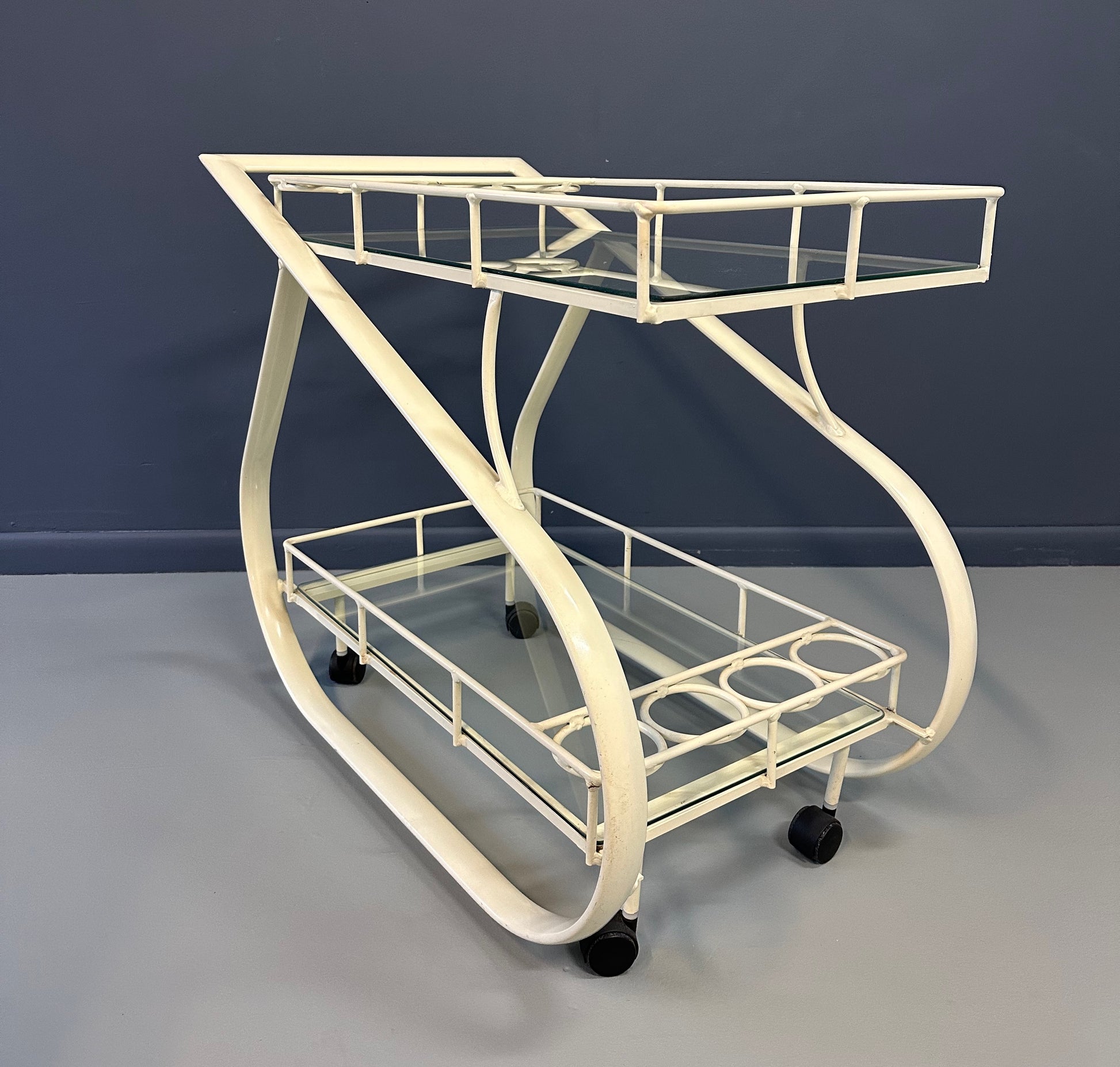 Vintage 1980s postmodern two-tier bar cart with curvy metal frame and glass shelves, attributed to Woodard