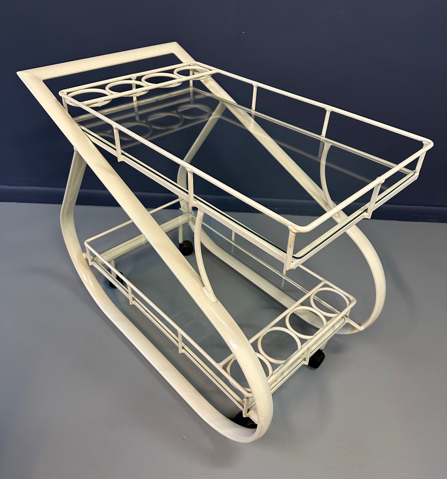 Vintage 1980s postmodern two-tier bar cart with curvy metal frame and glass shelves, attributed to Woodard