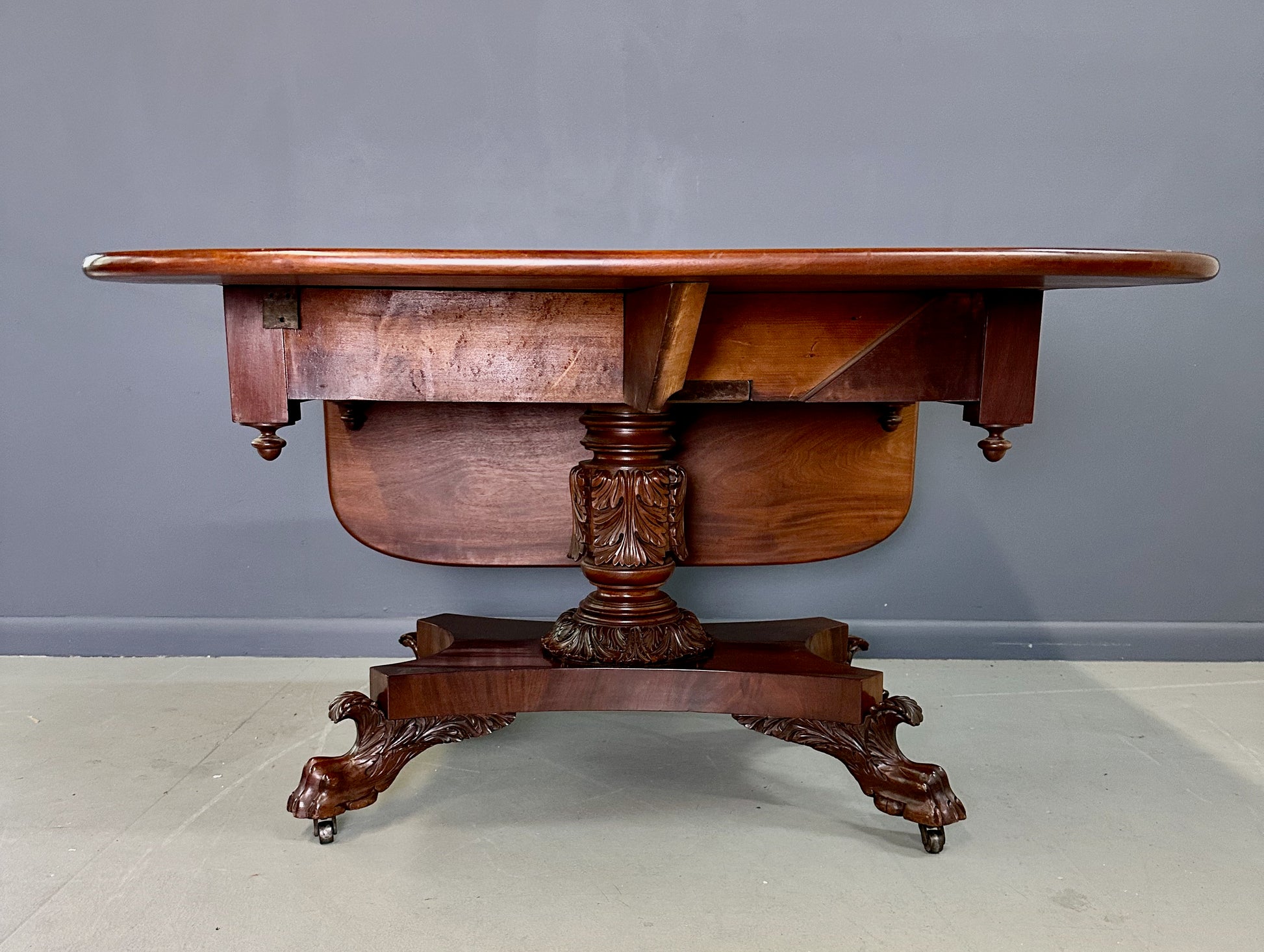 Circa 1845 Anthony Querville drop-leaf table in rich mahogany with carved pedestal base, acanthus detailing, and claw feet—classic American Empire antique furniture