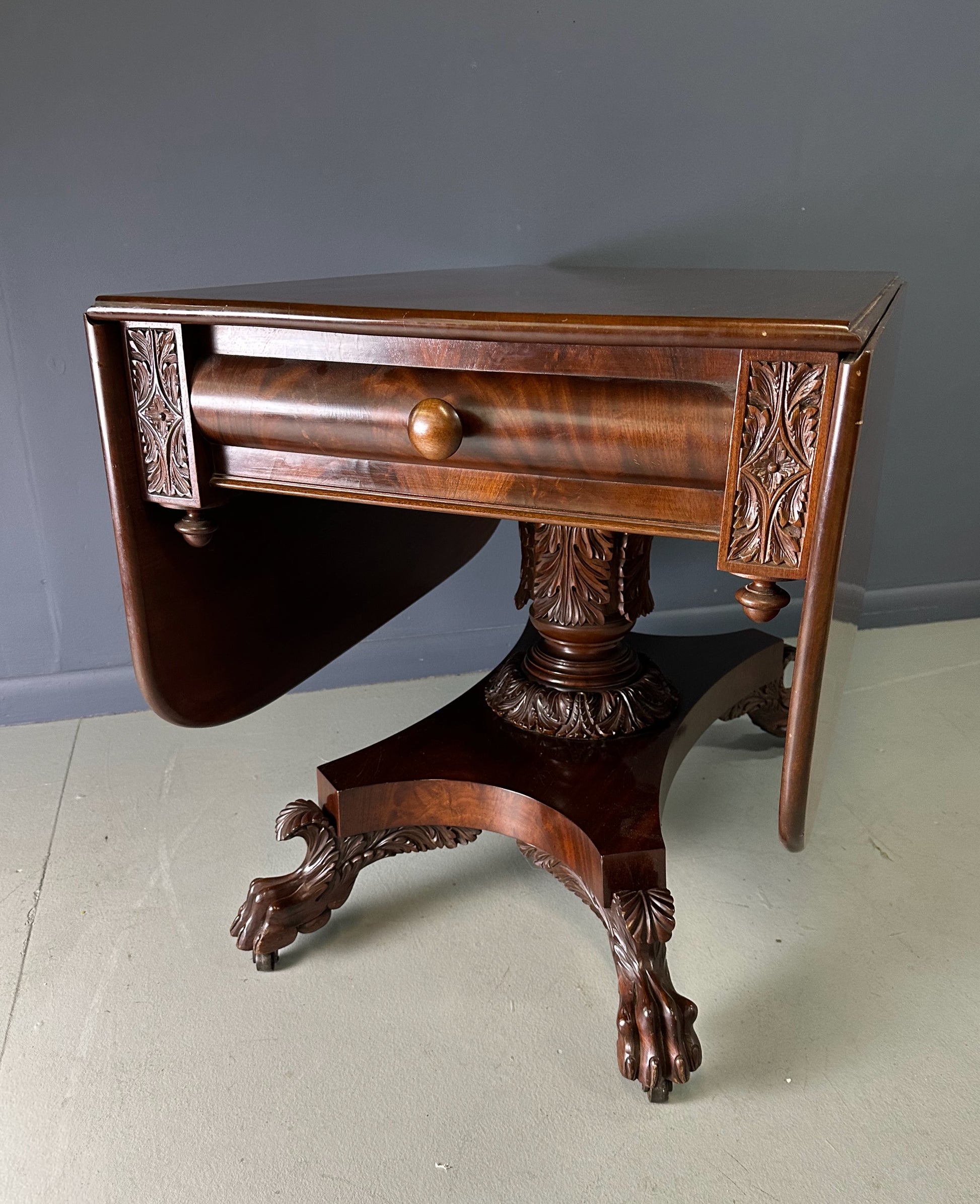 Circa 1845 Anthony Querville drop-leaf table in rich mahogany with carved pedestal base, acanthus detailing, and claw feet—classic American Empire antique furniture