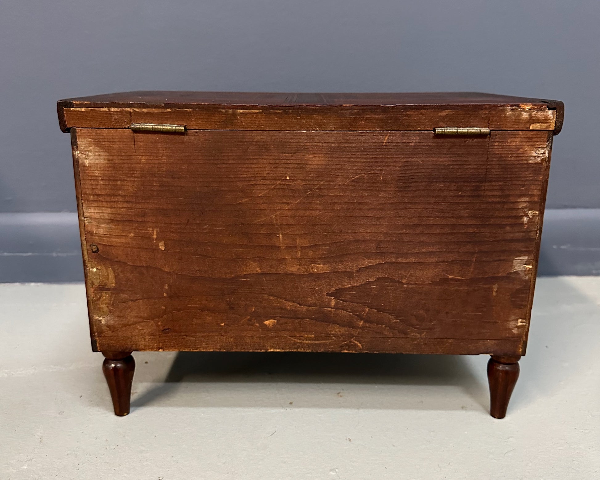 Miniature marquetry blanket chest dated 1910, handcrafted by Flora Boyer of Pennsylvania, featuring intricate geometric inlay patterns in warm-toned wood and a brass keyhole on the front