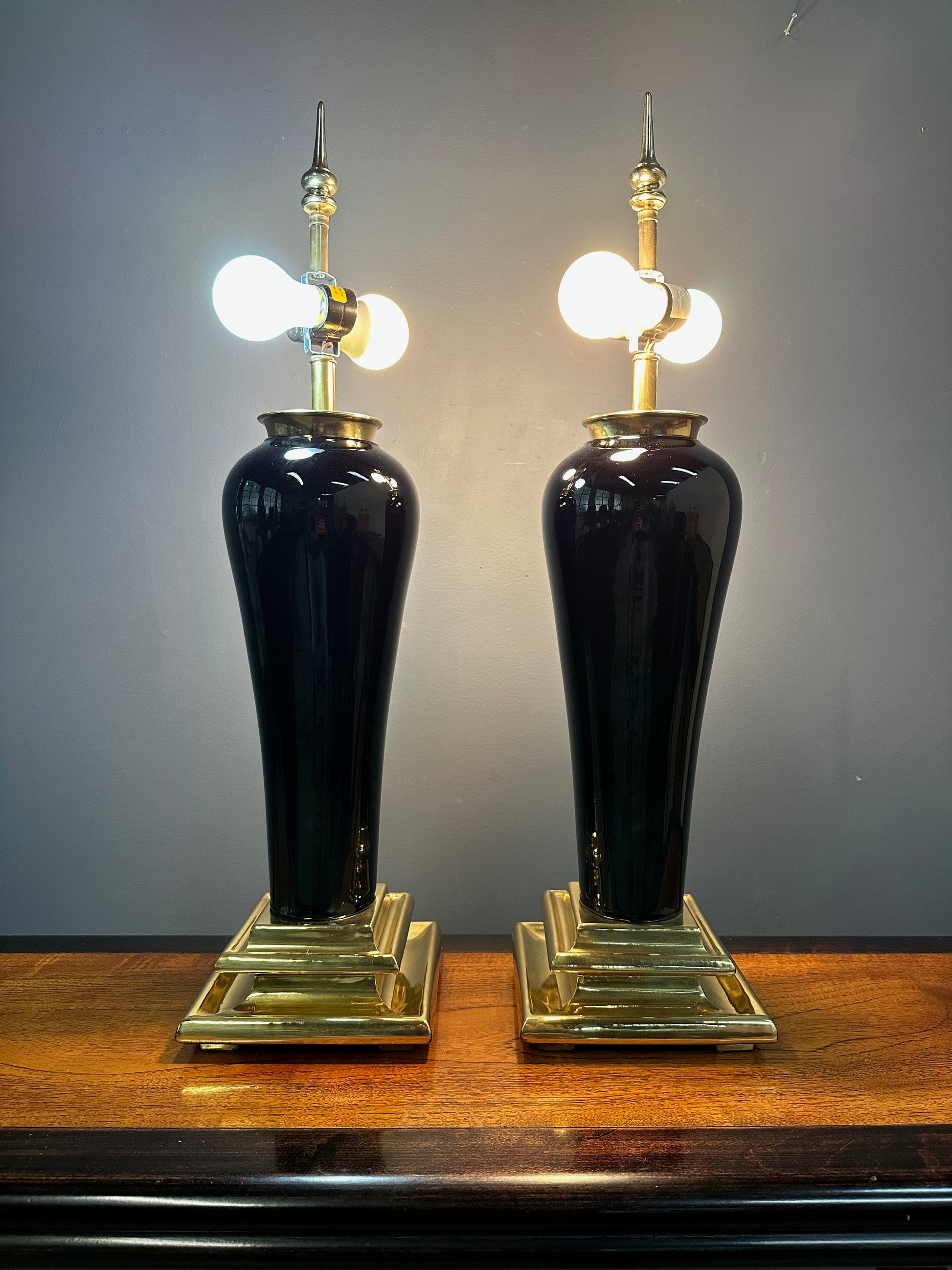 Pair of Hollywood Regency Black Ceramic Urn Lamps with Stepped Brass Bases by Chapman