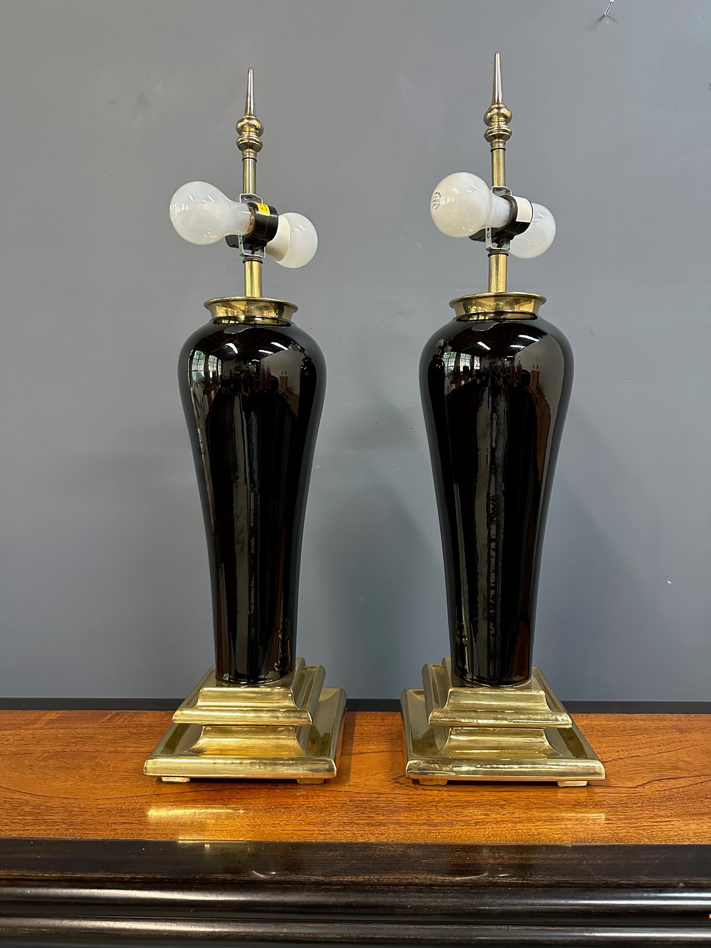 Pair of Hollywood Regency Black Ceramic Urn Lamps with Stepped Brass Bases by Chapman