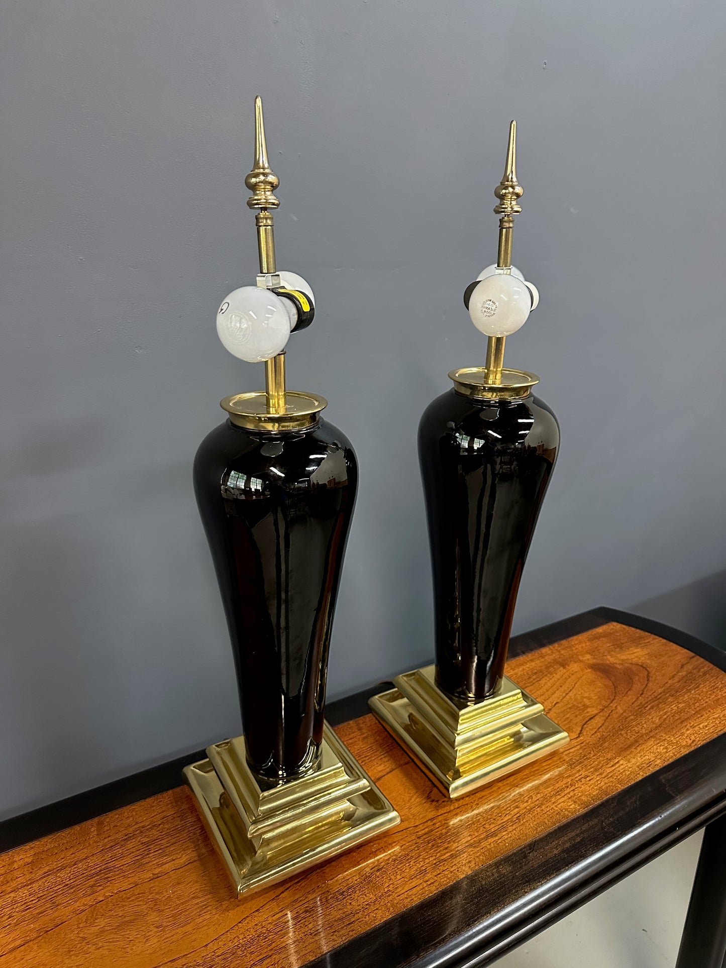 Pair of Hollywood Regency Black Ceramic Urn Lamps with Stepped Brass Bases by Chapman