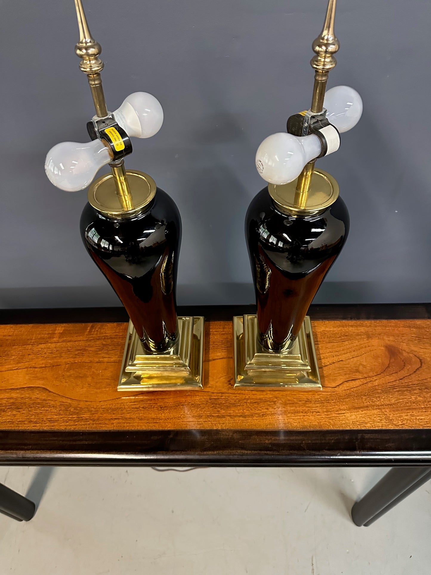 Pair of Hollywood Regency Black Ceramic Urn Lamps with Stepped Brass Bases by Chapman