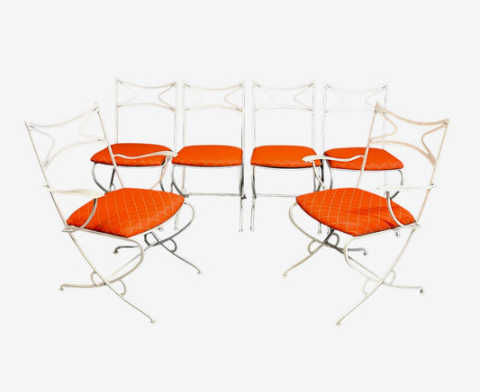 1940s French mid-century modern outdoor dining set featuring six white wrought iron chairs with orange diamond-patterned cushions and a matching table with decorative curved frames
