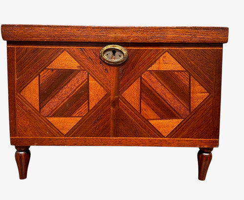 Miniature marquetry blanket chest dated 1910, handcrafted by Flora Boyer of Pennsylvania, featuring intricate geometric inlay patterns in warm-toned wood and a brass keyhole on the front